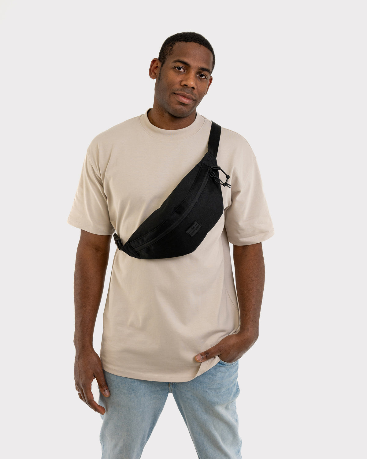 Mann trägt schwarze Bauchtasche 'Erik Large' von Johnny Urban diagonal über der Brust