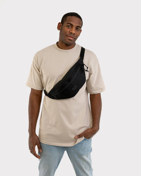 Mann trägt schwarze Bauchtasche 'Erik Large' von Johnny Urban diagonal über der Brust