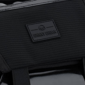 Nahaufnahme des Johnny Urban Logos auf der wasserabweisenden schwarzen Handtasche 'Liv'