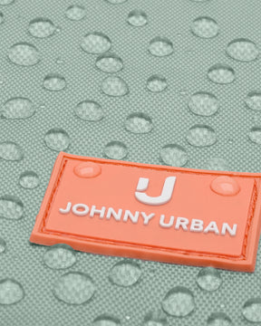 Nahaufnahme eines mintfarbenen Kinder-Turnbeutels mit orangefarbenem Johnny Urban Junior Logo und Wassertropfen