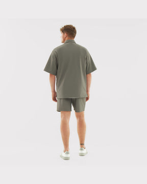Männliches Model von hinten mit olivfarbenen lockeren Shorts "Mason" und passendem Hemd