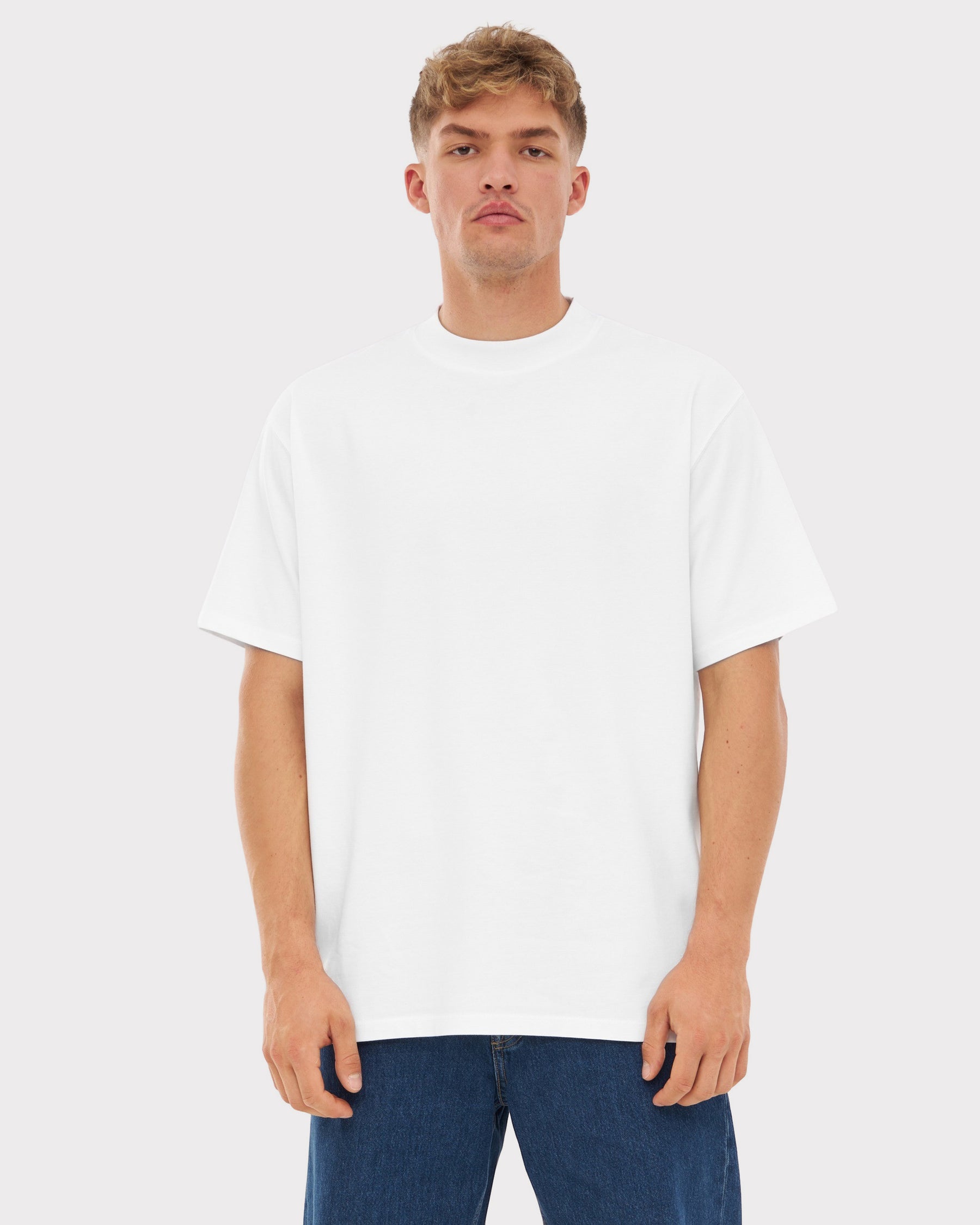 Mann trägt weißes Oversize-T-Shirt ohne Aufdruck und blaue Jeans