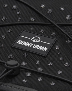 Nahaufnahme des schwarzen wasserabweisenden Reiserucksacks 'Allen XL Travel' mit JOHNNY URBAN Logo und Wassertropfen