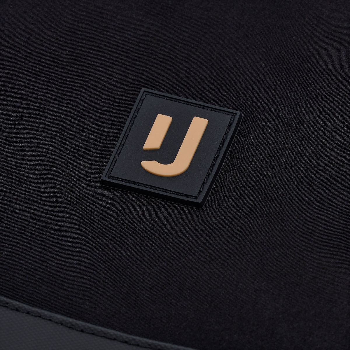 Nahaufnahme des Johnny Urban Logos auf dem schwarzen Stoff der wasserabweisenden Tote Bag 'Jessy'