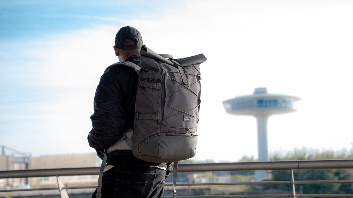 Ein Mann steht mit einem Johnny Urban Rucksack der Travel Series in der Hamburger Hafencity. 