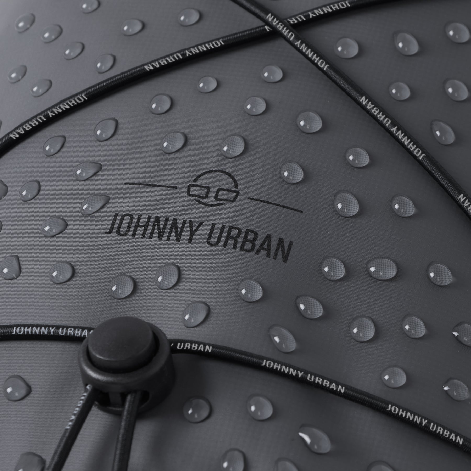 Nahaufnahme der wasserabweisenden Oberfläche und der Kordel mit ‚Johnny Urban‘-Branding der trockenen Tasche ‚Theo‘
