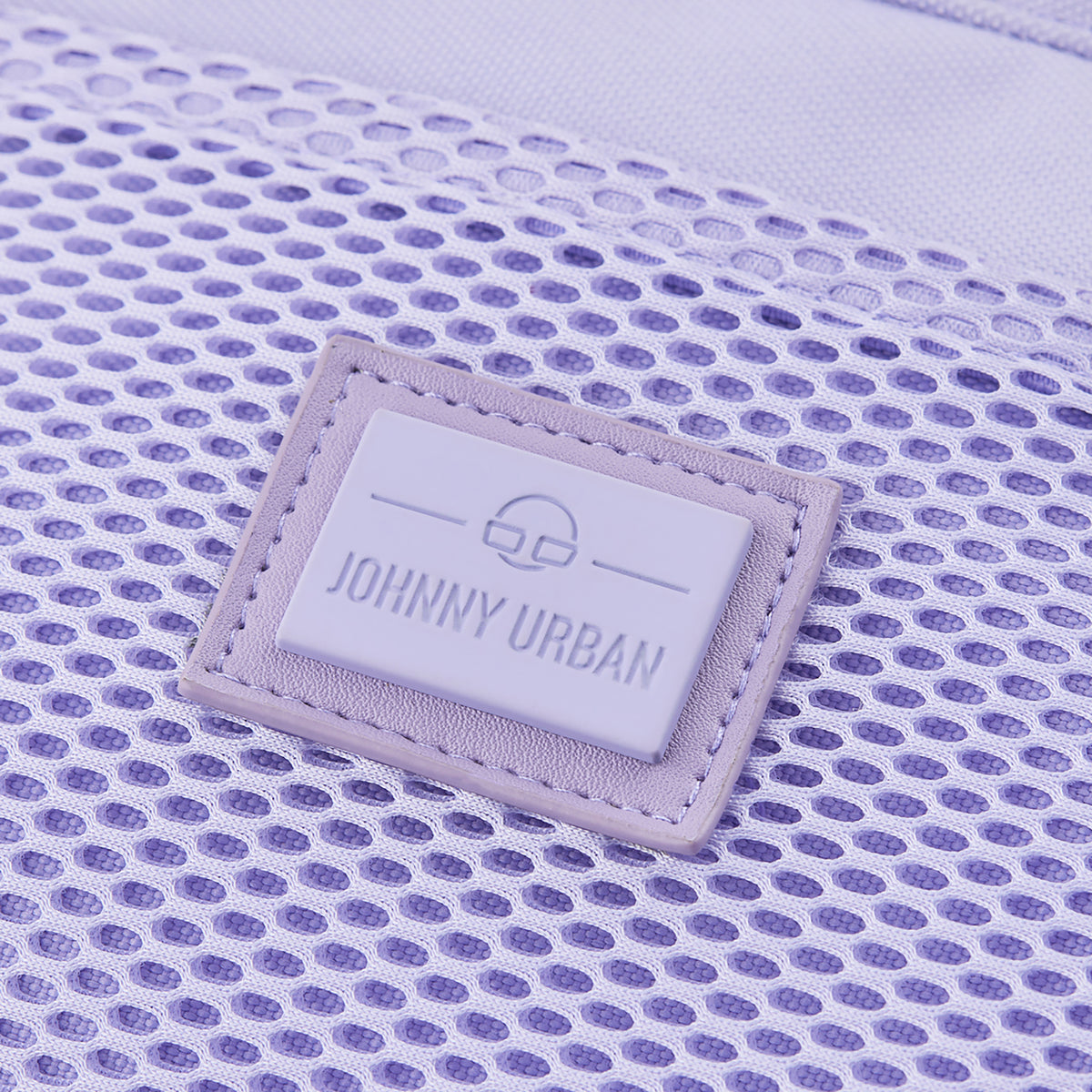Nahaufnahme des Johnny Urban Logos auf der lilafarbenen Handtasche 'Maddy' mit Netzstruktur