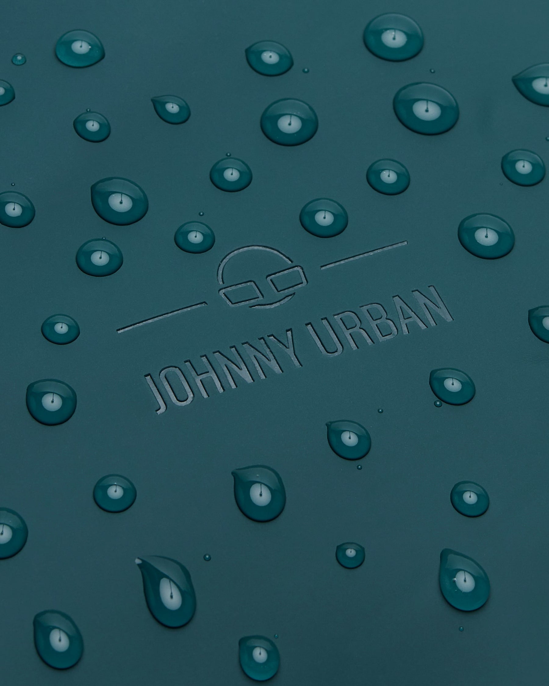 Wasserabweisendes Material des Rucksacks 'Hailey' in Petrolgrün mit Wasserperlen und eingeprägtem Johnny Urban Logo