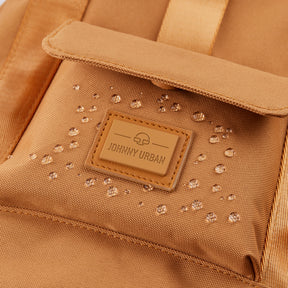 Nahaufnahme des wasserabweisenden caramel-braunen Rucksacks 'Jules' von Johnny Urban mit Wassertropfen auf der Oberfläche